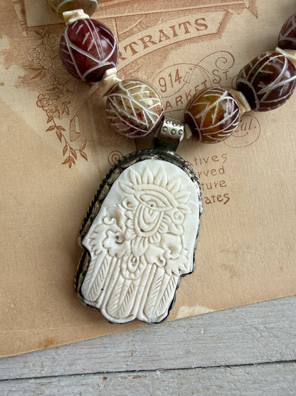 Carved red jade with carved bone hamsa short necklace.