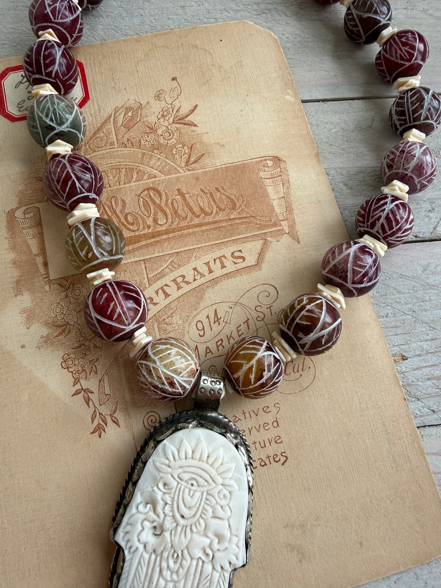 Carved red jade with carved bone hamsa short necklace.