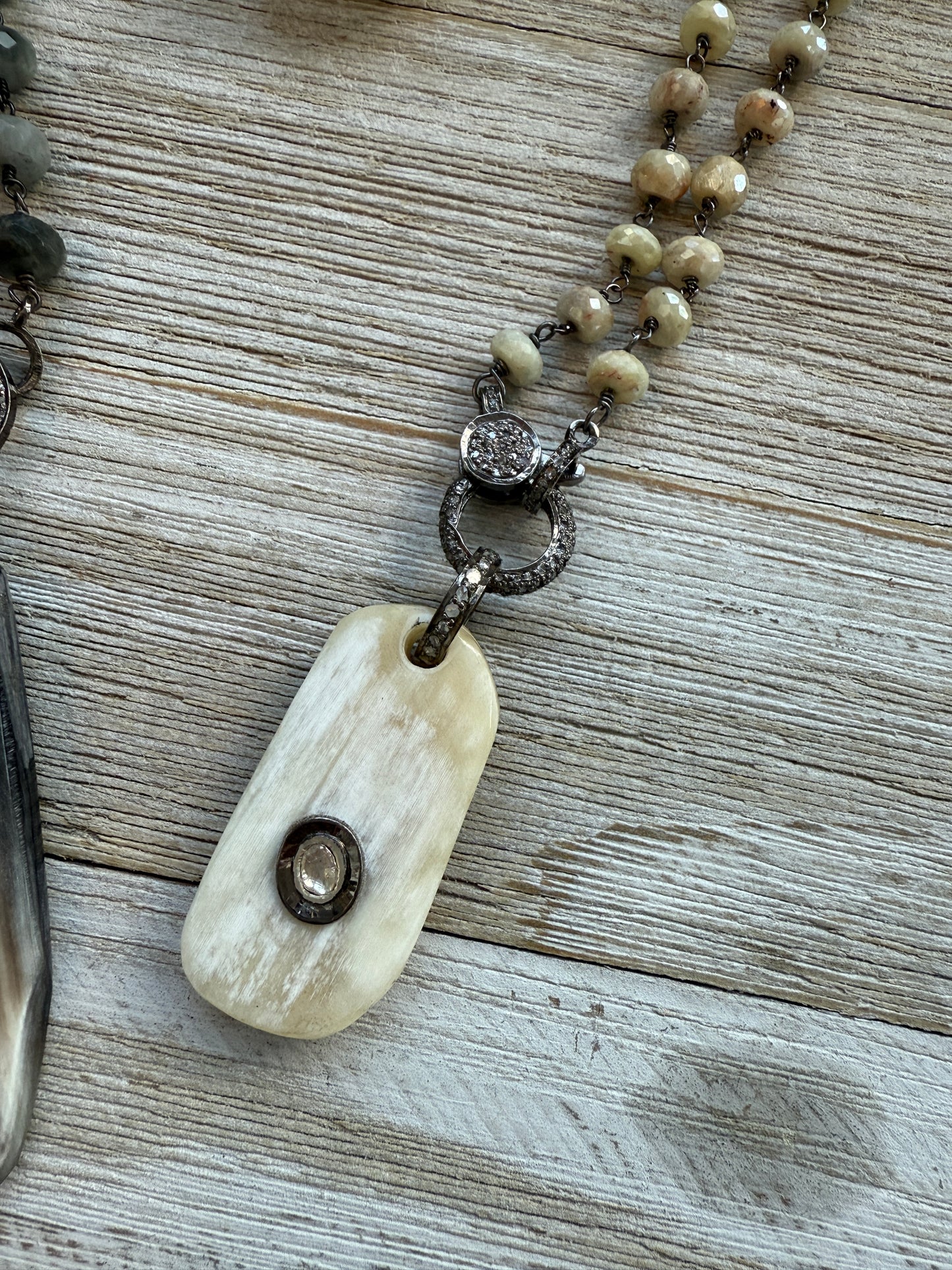 Cream colored bone pendant with inlayed Polki diamond; diamond bale and clasp, cream silverite chain necklace. 31.5” chain.