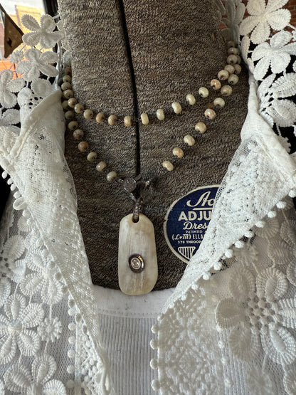 Cream colored bone pendant with inlayed Polki diamond; diamond bale and clasp, cream silverite chain necklace. 31.5” chain.