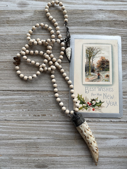 Carved bone on cream riverstone, smoky quartz accents long necklace. 36”