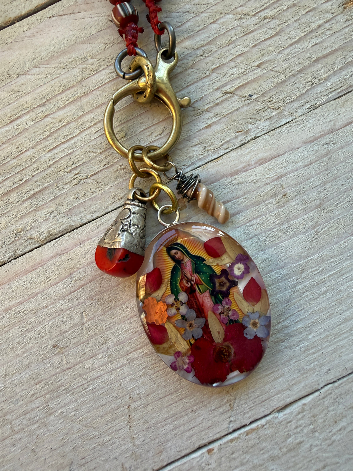 Our Lady. Dried flowers under resin. Handmade with sterling bezel on knotted striped Java beads. 35” necklace.
