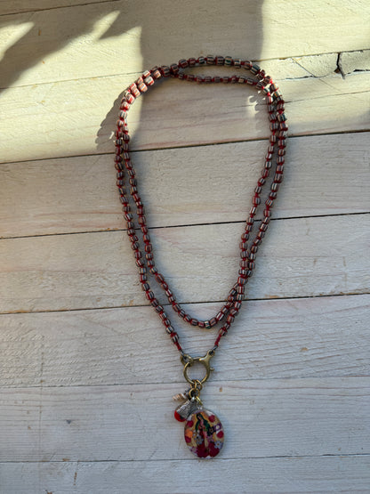 Our Lady. Dried flowers under resin. Handmade with sterling bezel on knotted striped Java beads. 35” necklace.