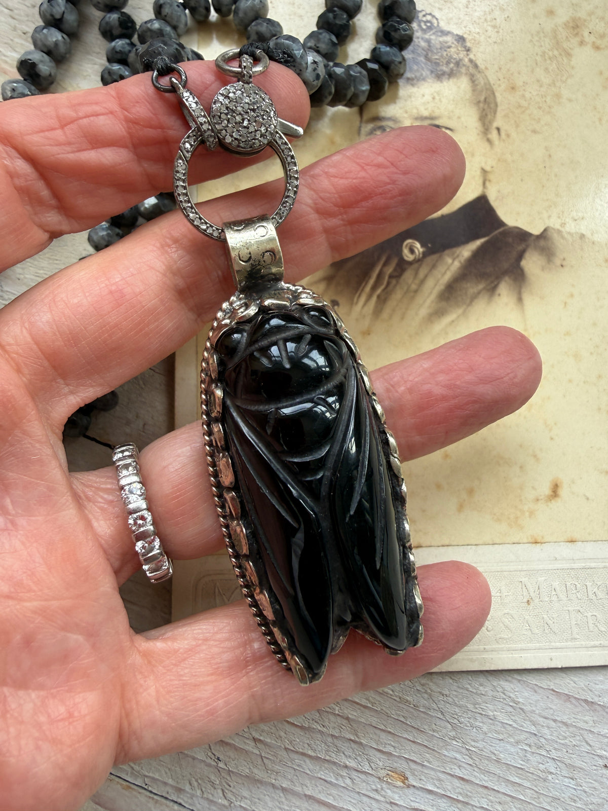 Tibetan Onyx cicada with diamond charm holder/clasp on knotted Norwegian moonstone necklace.