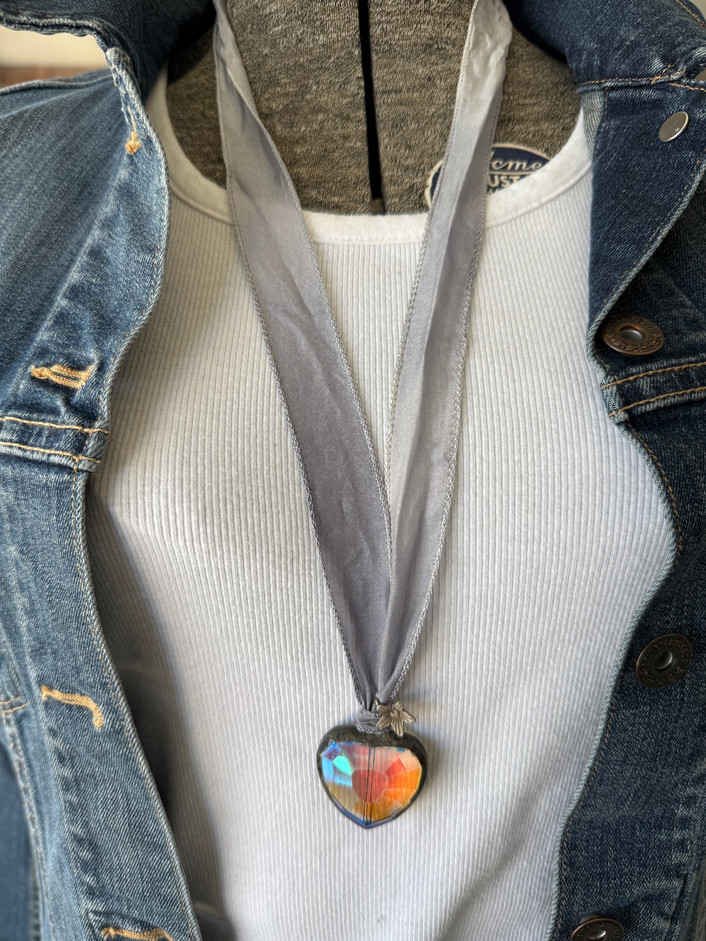 Prism heart on pale blue silk ribbon with fine silver flower charms. 36”.