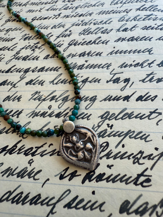 Old sterling silver Tibetan pendant on faceted variegated turquoise necklace. 15.5-16”