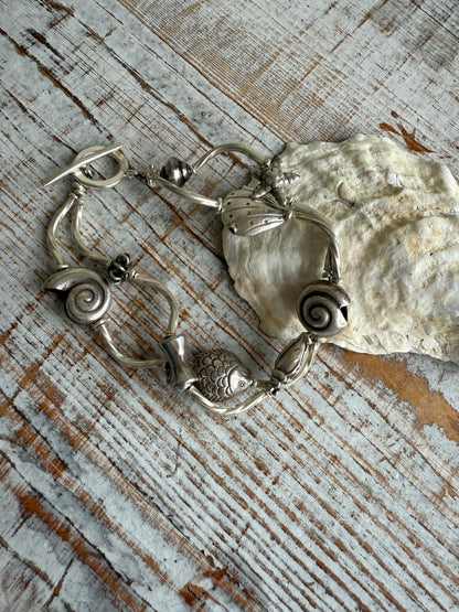 Fine silver sealife and shell bracelet with toggle clasp. 7”.