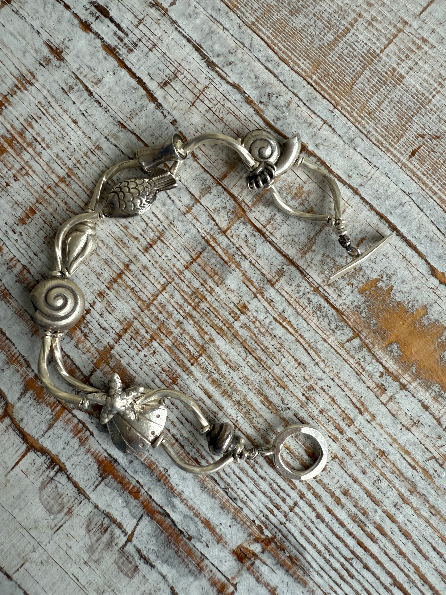 Fine silver sealife and shell bracelet with toggle clasp. 7”.