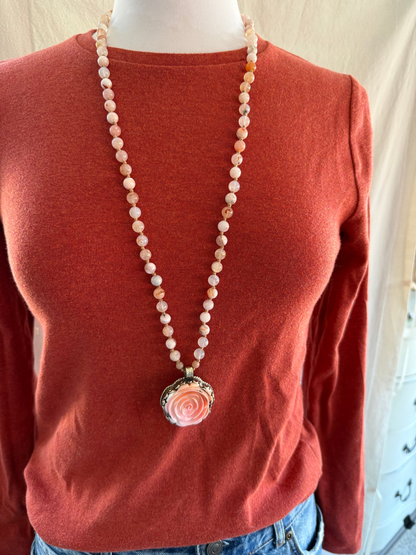 Hand carved pink Opal Tibetan rose pendant hand knotted onto cherry blossom agates necklace. 34” long.