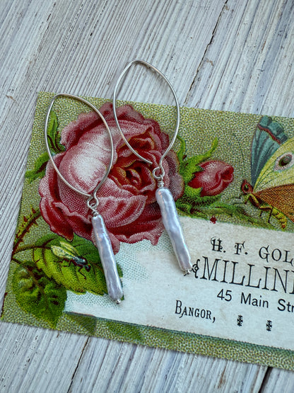 White stick pearl dangle earrings.