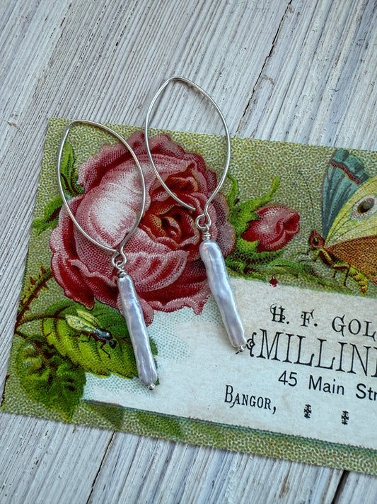 White stick pearl dangle earrings.