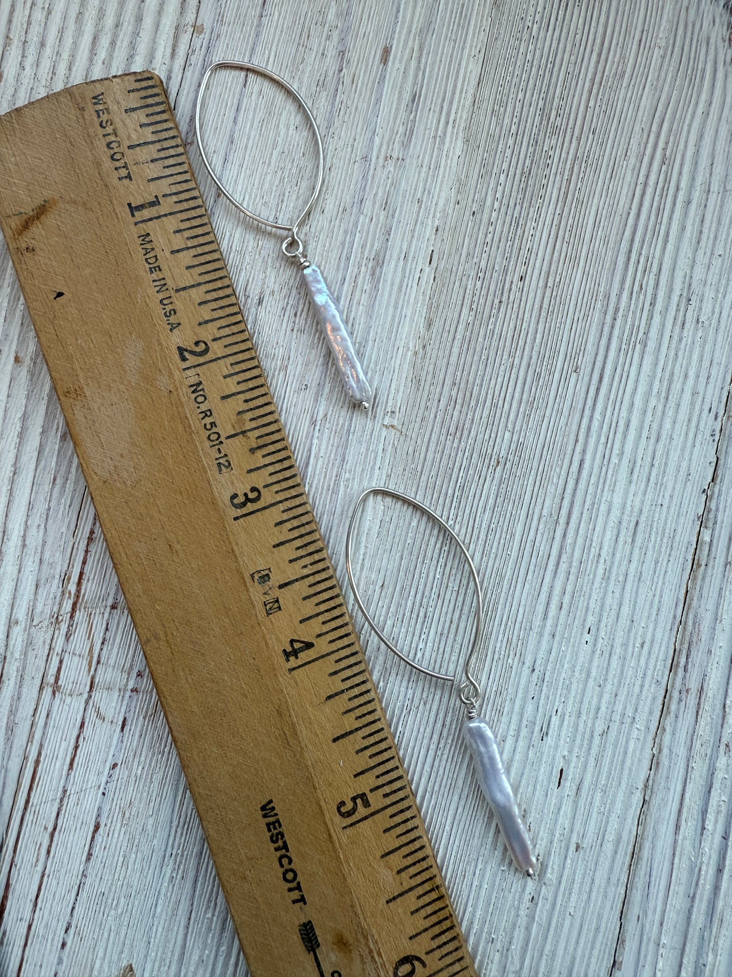 White stick pearl dangle earrings.