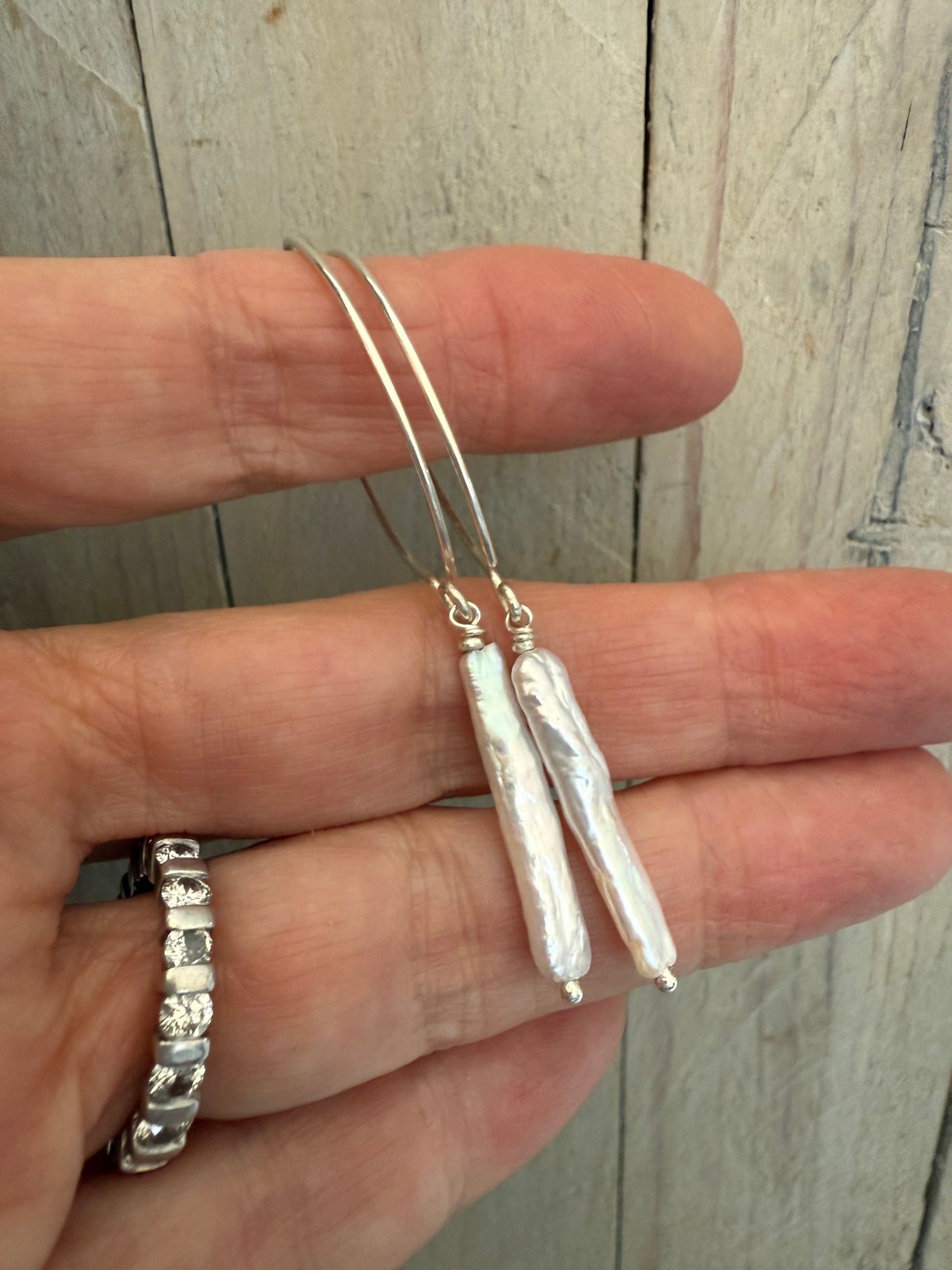 White stick pearl dangle earrings.