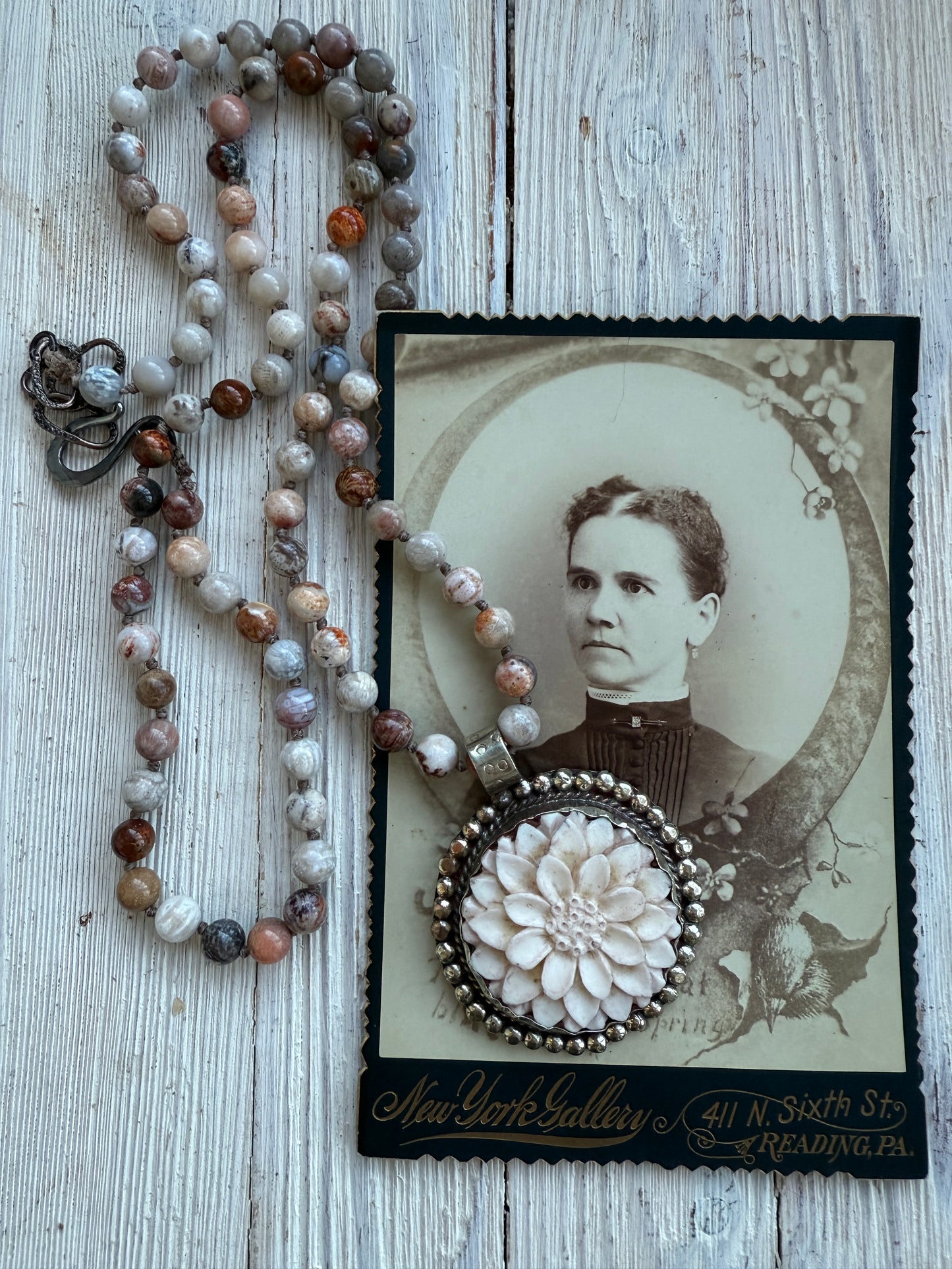 Tibetan carved bone dahlia on knotted fossilized coral long necklace.