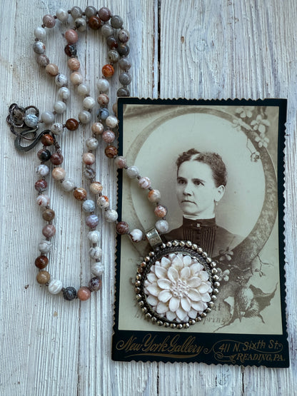 Tibetan carved bone dahlia on knotted fossilized coral long necklace.