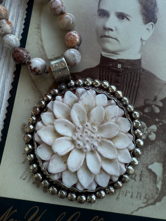 Tibetan carved bone dahlia on knotted fossilized coral long necklace.