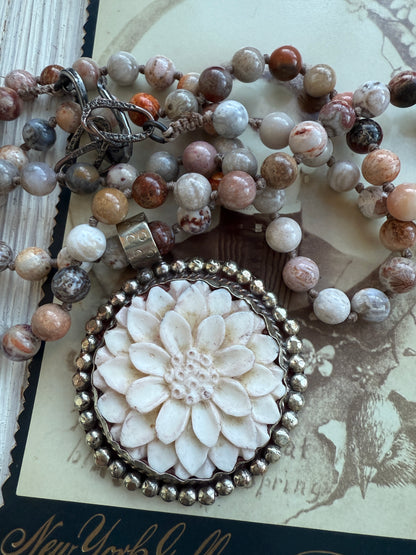 Tibetan carved bone dahlia on knotted fossilized coral long necklace.