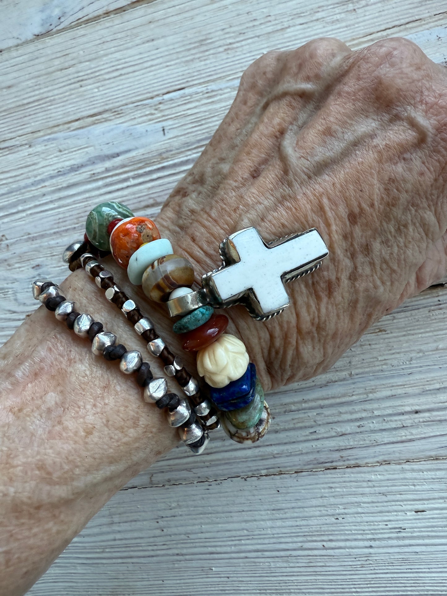 A bone cross adorns this beaded stretch bracelet. 7”