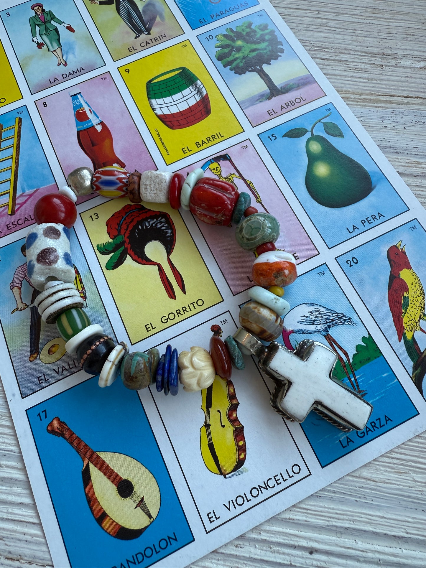 A bone cross adorns this beaded stretch bracelet. 7”