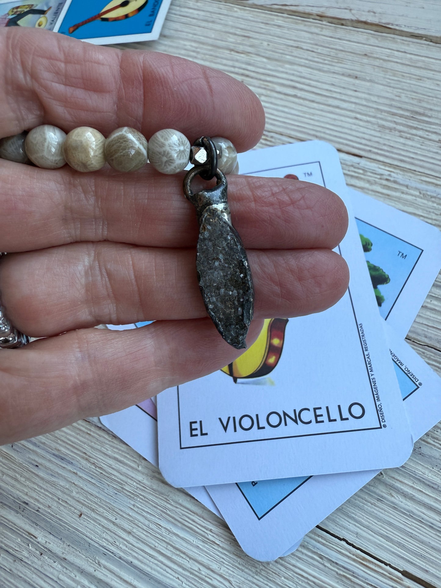 Smoky quartz druzie hangs from a stack bracelet of fossil coral beads 6.5-7”.