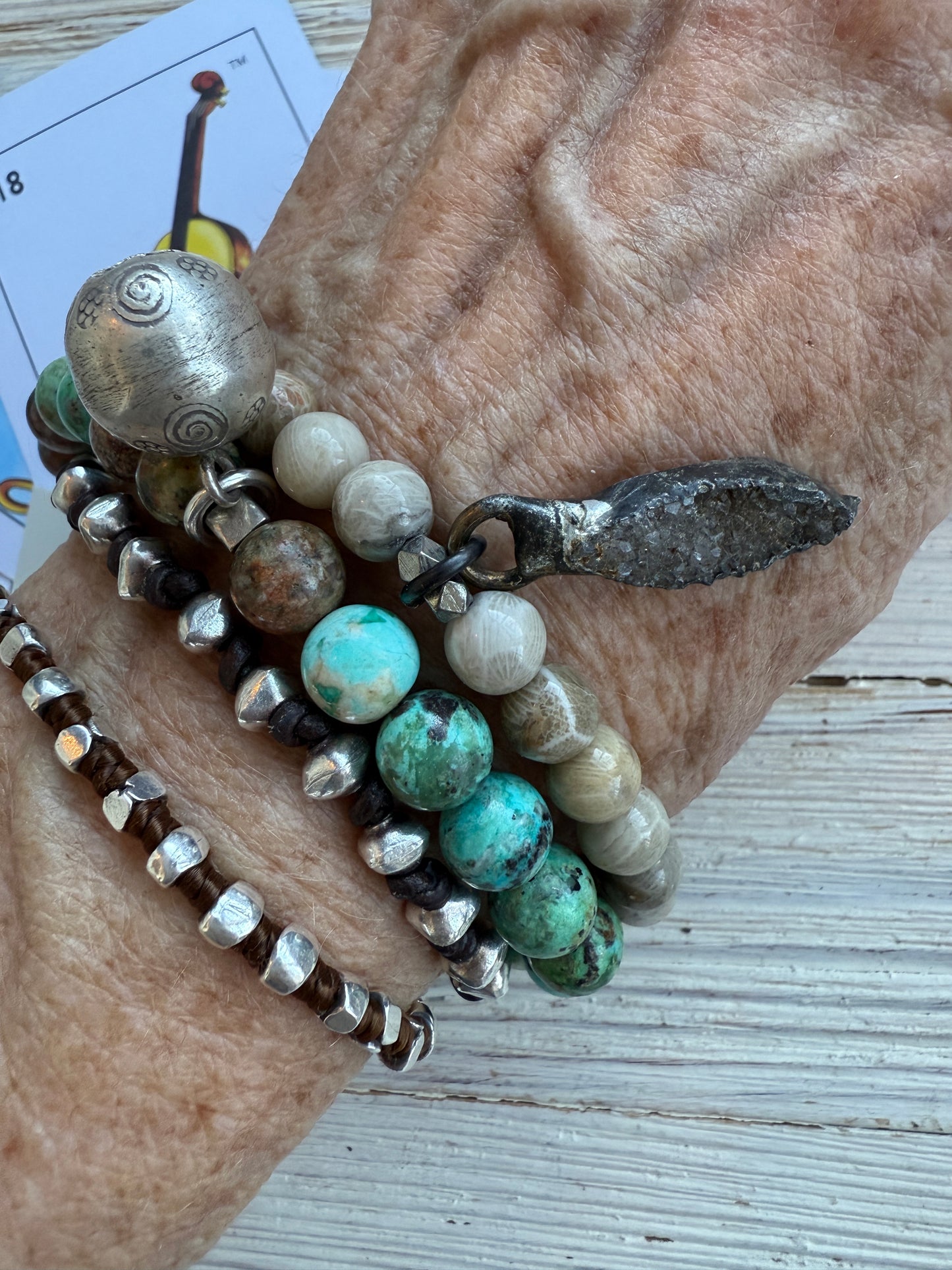 Smoky quartz druzie hangs from a stack bracelet of fossil coral beads 6.5-7”.