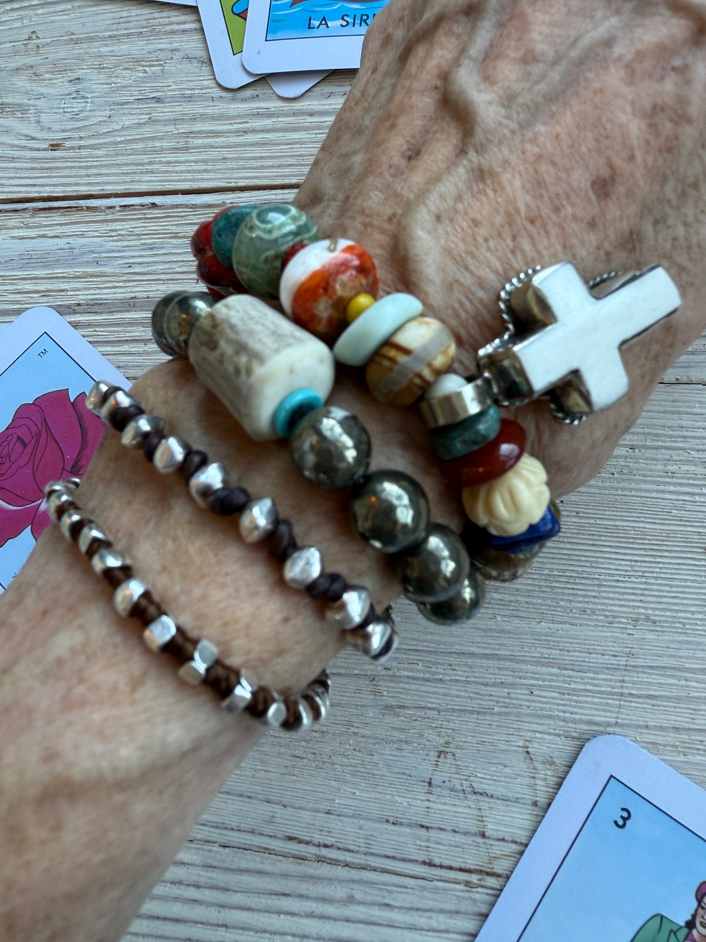 A bone cross adorns this beaded stretch bracelet. 7”