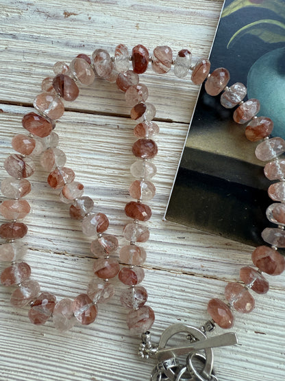 Hematoid quartz with fine silver spacers with fine silver rosebud, rose, and leaf on a fine silver front toggle necklace. 18”