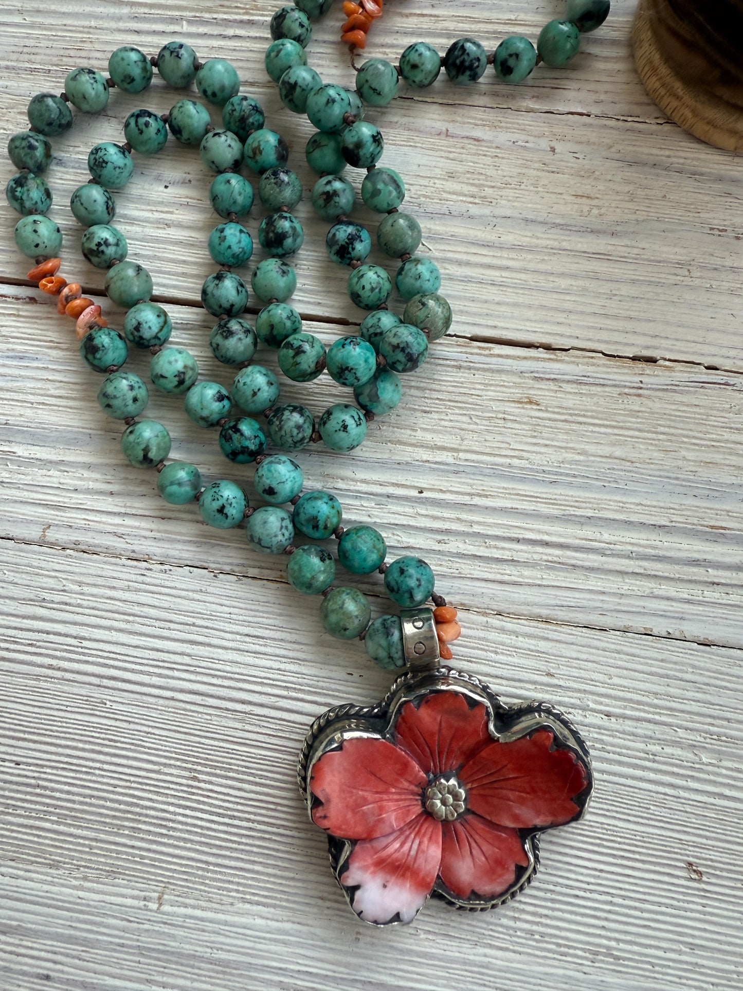 Spiny oyster flower pendant from Tibet on knotted turquoise with spiny oyster accents. 34” long necklace.