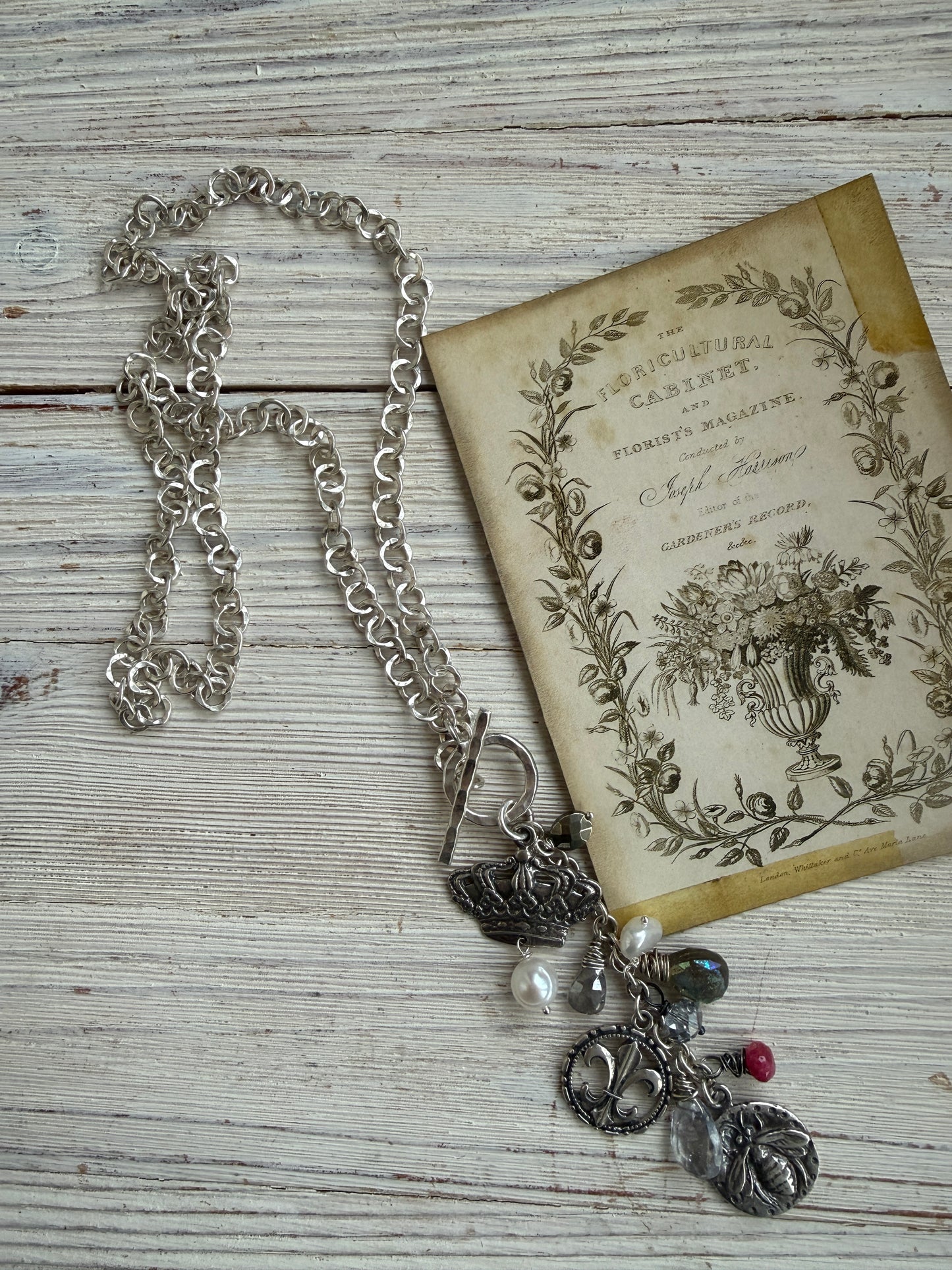 Sterling silver crown, fleur de lis, and bee charms on long fine silver chain. 25.5”