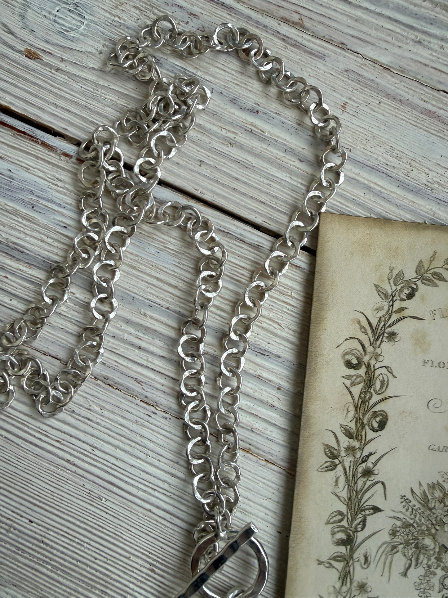 Sterling silver crown, fleur de lis, and bee charms on long fine silver chain. 25.5”