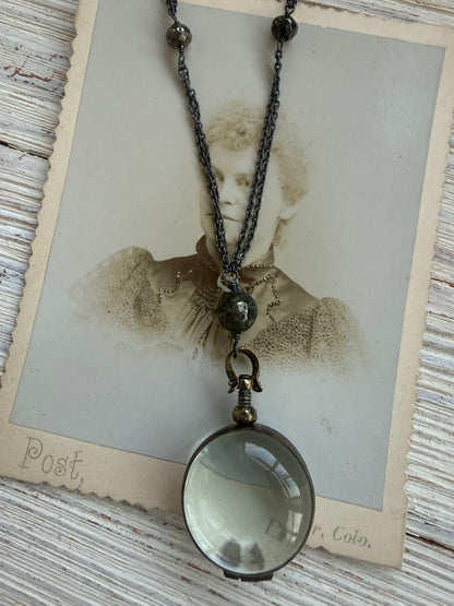 Antiqued bronze locket on sterling silver and pyrite chain. 32” necklace.