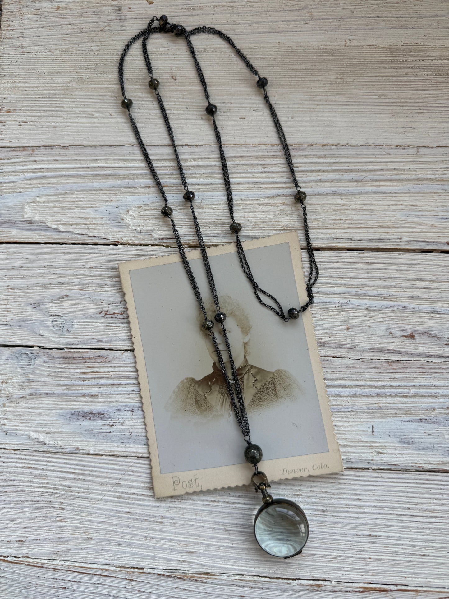 Antiqued bronze locket on sterling silver and pyrite chain. 32” necklace.