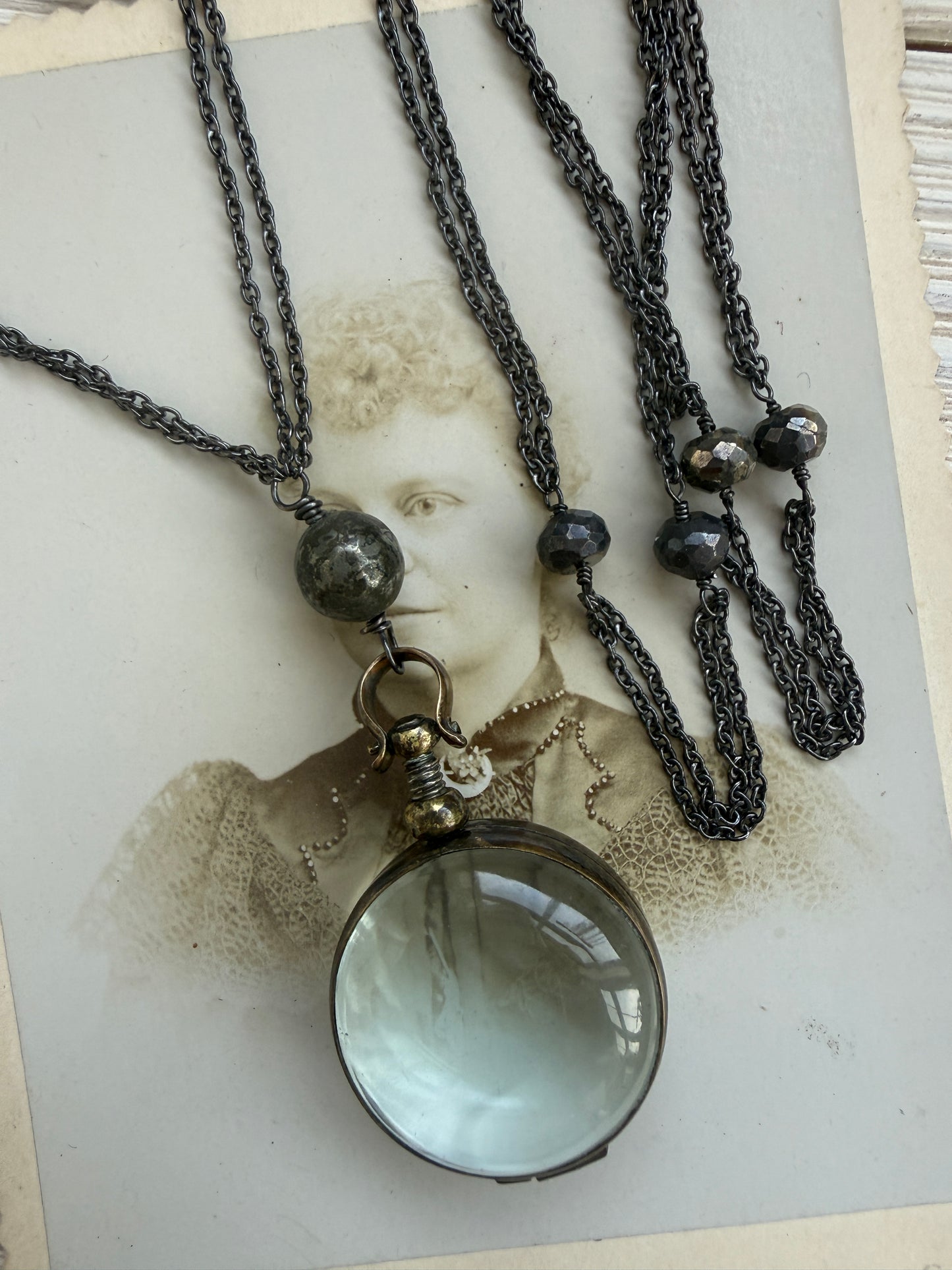 Antiqued bronze locket on sterling silver and pyrite chain. 32” necklace.