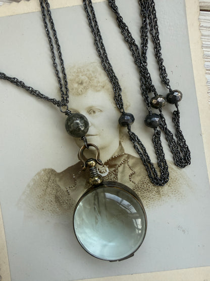 Antiqued bronze locket on sterling silver and pyrite chain. 32” necklace.