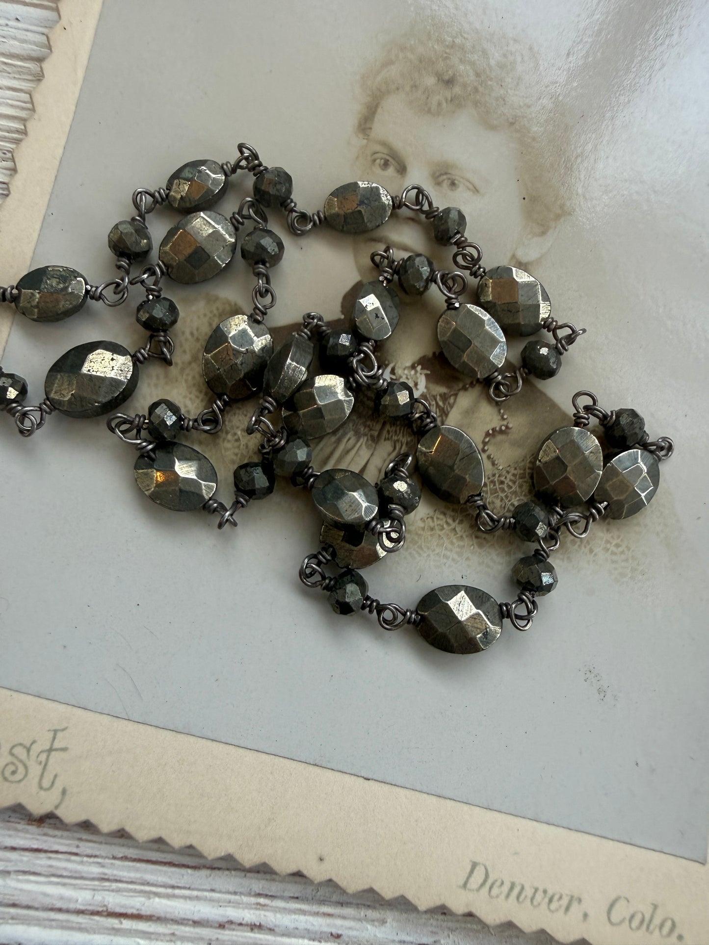 Antiqued sterling locket on faceted pyrite chain. 34” long necklace.
