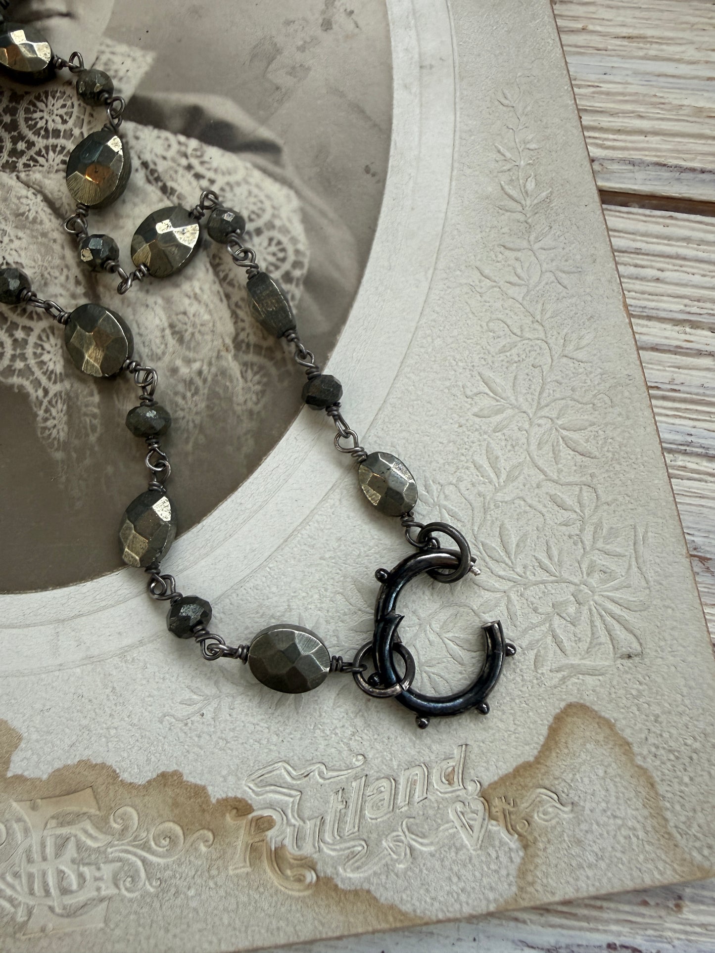 Antiqued sterling locket on faceted pyrite chain. 34” long necklace.