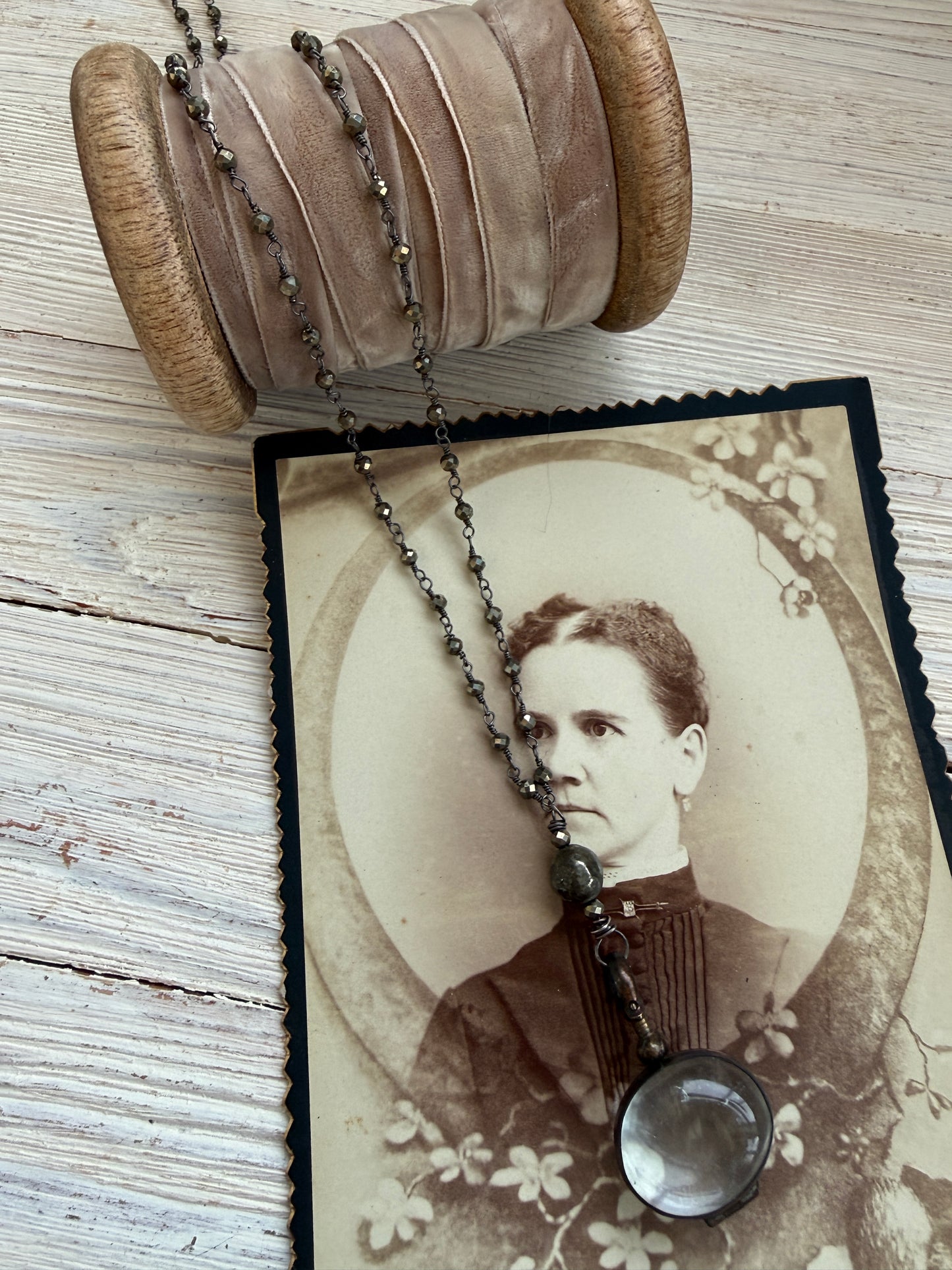 Antiqued bronze glass locket on pyrite chain. 32”