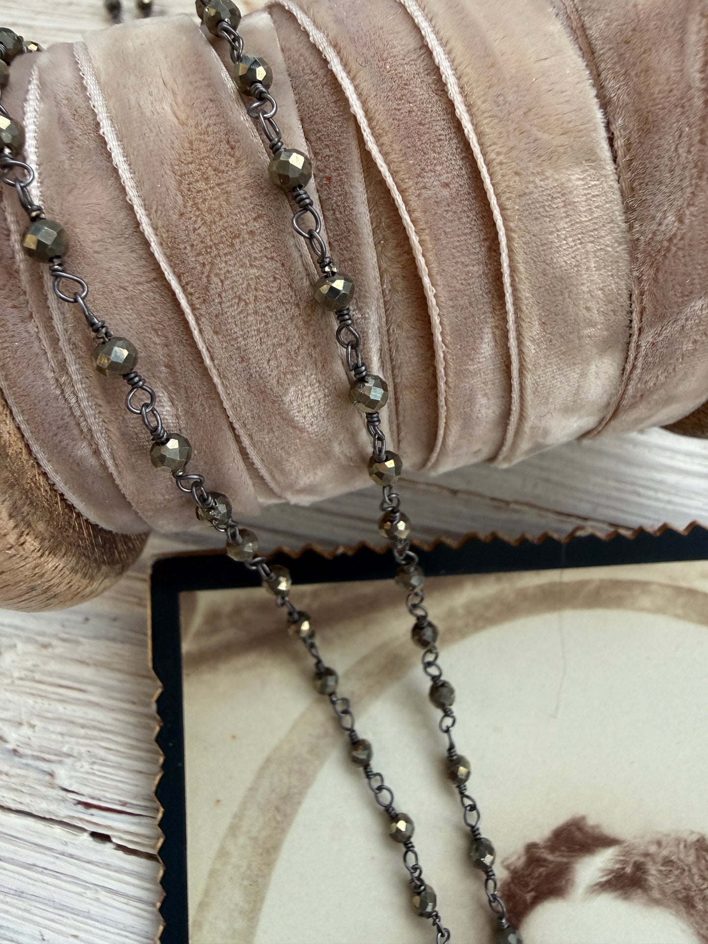 Antiqued bronze glass locket on pyrite chain. 32”