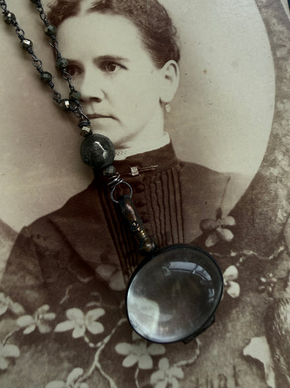 Antiqued bronze glass locket on pyrite chain. 32”