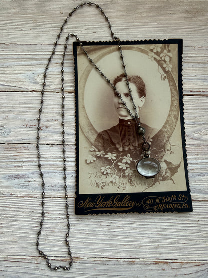 Antiqued bronze glass locket on pyrite chain. 32”