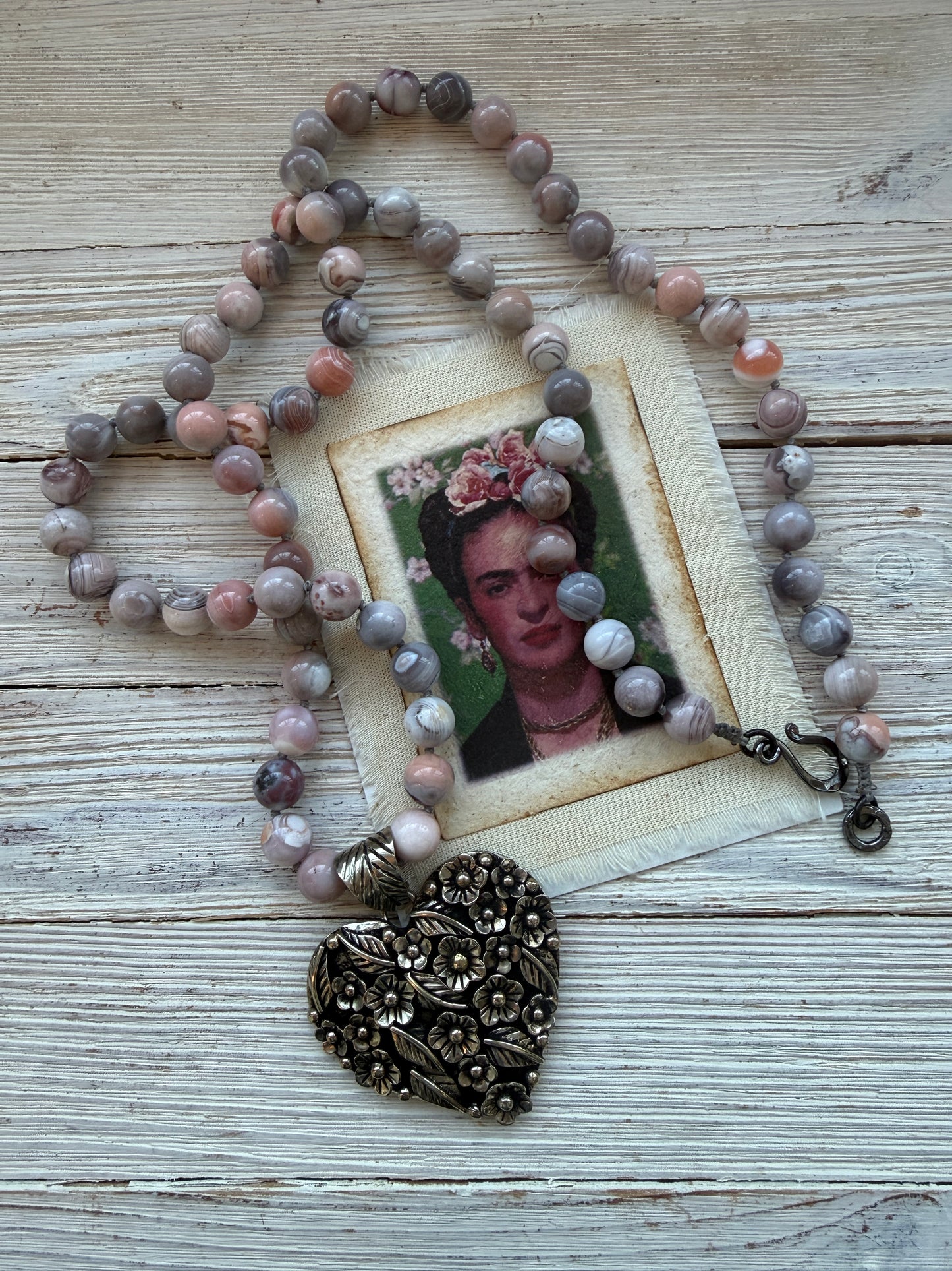 Tibetan flowered heart pendant on pink Botswana agates long necklace.
