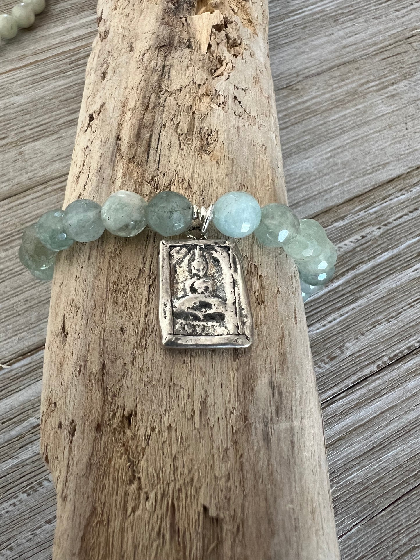 Bracelet of faceted aquamarines with a solid sterling silver sitting Buddha charm.