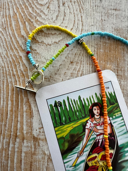 Primary colors surround a woven fine silver pendant necklace.