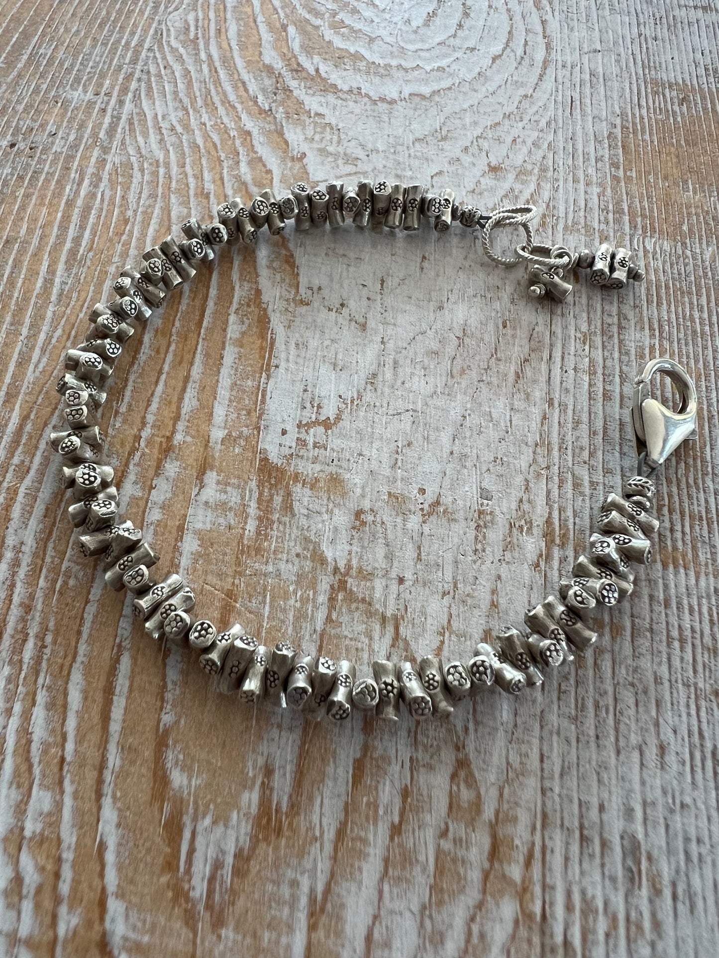 Tiny stamped logs of Thai silver form a great bracelet to add texture to any stack.