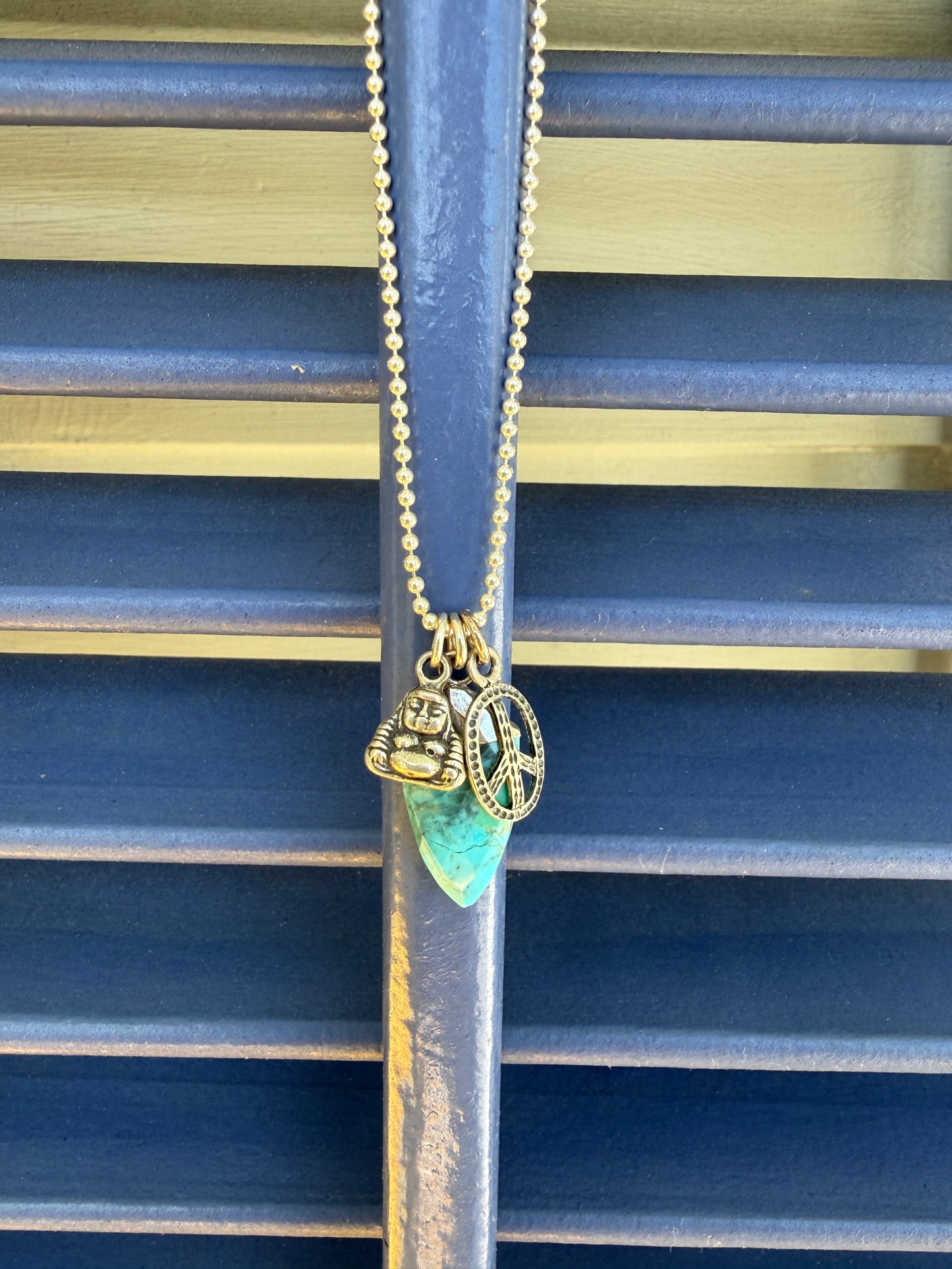 Turquoise spear with sterling Buddha and peace charms on sterling ball chain necklace. 18”
