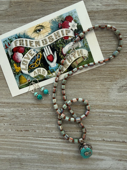 Tibetan turquoise pendant on striped Java beads. Fine silver hook clasp. 21”.
