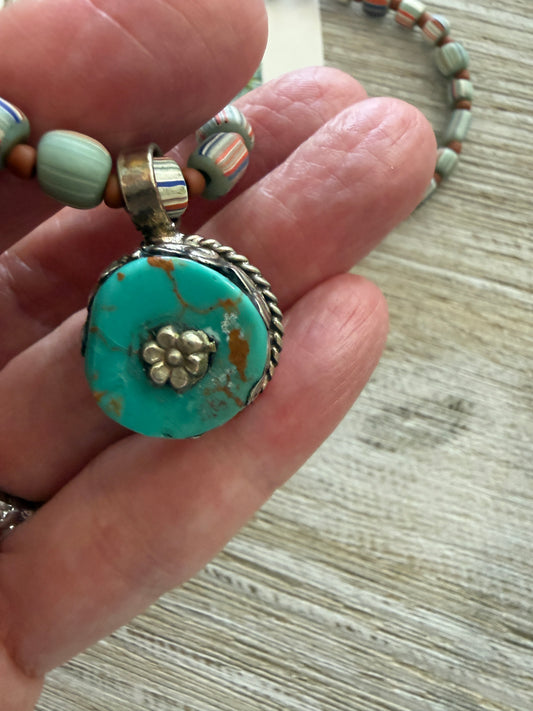 Tibetan turquoise pendant on striped Java beads. Fine silver hook clasp. 21”.