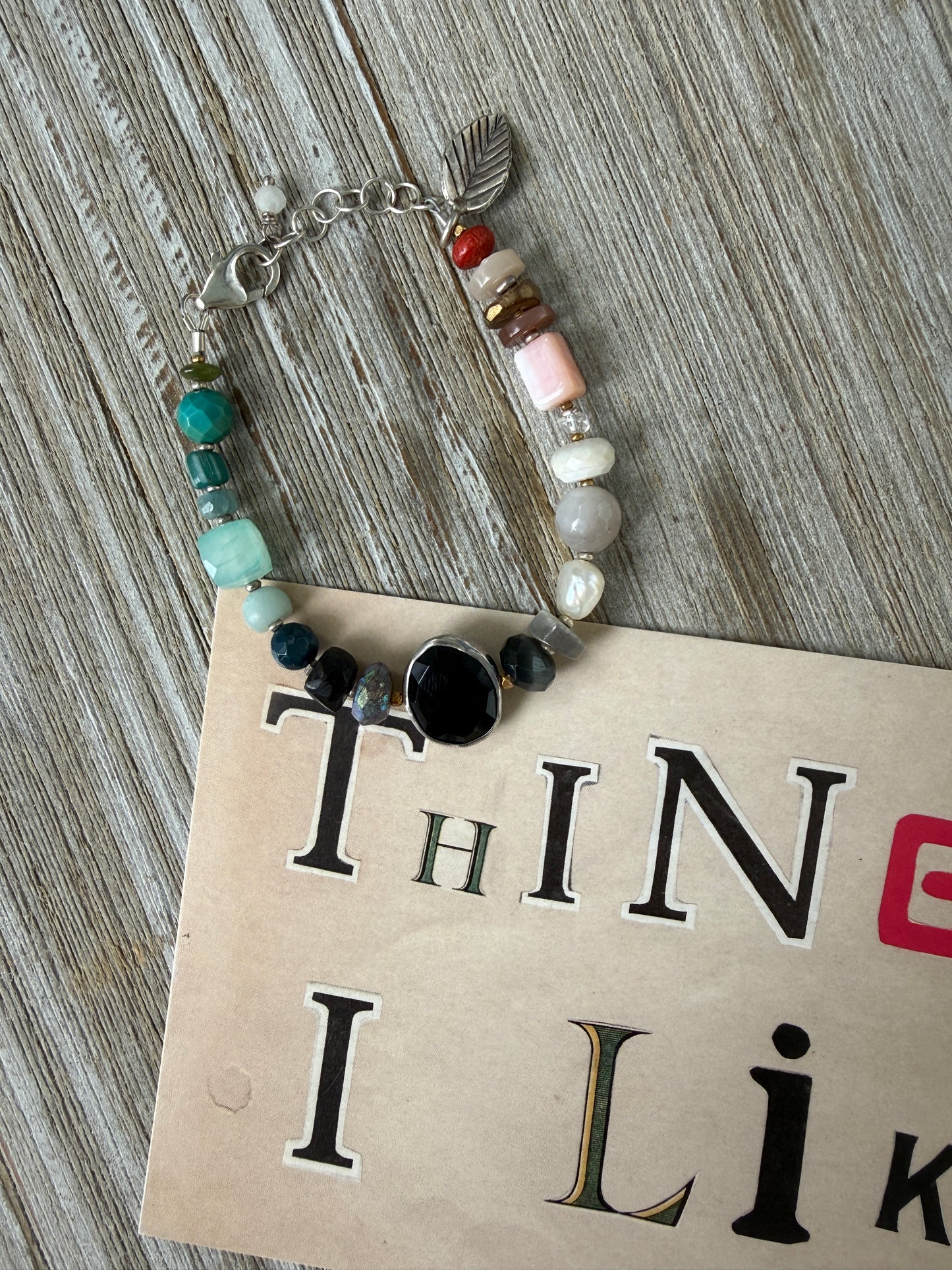Mixed gemstone bracelet with black onyx focal bead and sterling clasp and extender chain. 6-7”