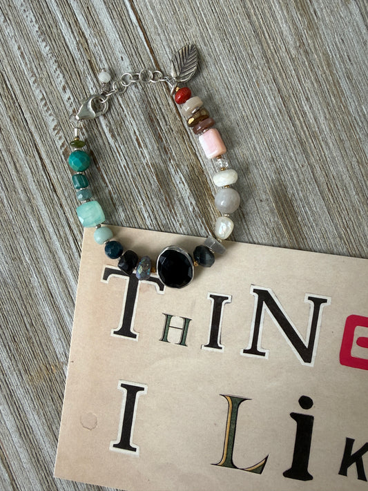 Mixed gemstone bracelet with black onyx focal bead and sterling clasp and extender chain. 6-7”