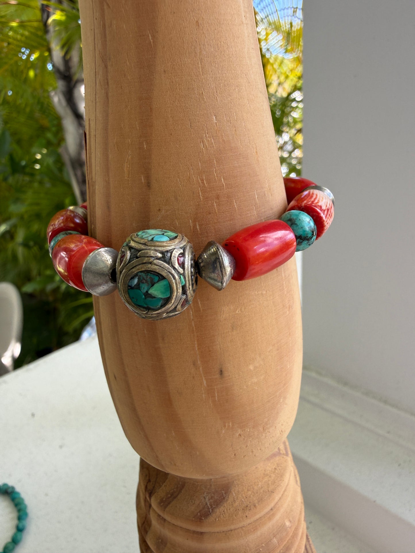 Old Tibetan bead with turquoise inlay surrounded by coral and turquoise beads stretch bracelet. 7”